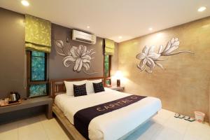 a bedroom with a large bed with flowers on the wall at Capital O 464 At Nata Chiangmai Chic Jungle in Mae Rim