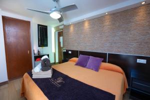 a bedroom with a large bed and a brick wall at Hostal Casa Mercedes in Nerja