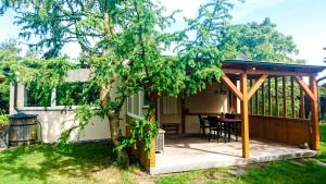 a pergola on a patio with a table in a yard at Ferienhaus Am Oberfeuer in Freest +7 photos