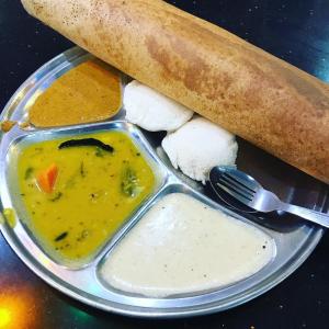 a plate of food with a bowl of soup and a bread at Hotel Temple City in Madurai