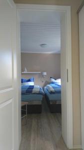 a room with two beds and a hallway with two beds at Ferienhaus Am Oberfeuer in Freest