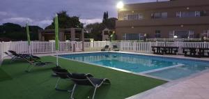 a swimming pool with chairs and a building at Falling Waters Guest House in Margate