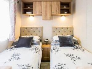 two beds sitting next to each other in a room at Cairn View Chalet in Aviemore
