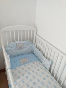 a white crib with a blue blanket on it at Casa da Rosarinha in Água de Alto