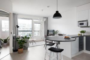 uma cozinha e sala de estar com mesa e cadeiras em SleepWell Apartment Rio with private sauna and parking em Helsinque