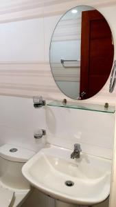 La salle de bains est pourvue d'un lavabo, d'un miroir et de toilettes. dans l'établissement The Pub Hotel, à Olongapo