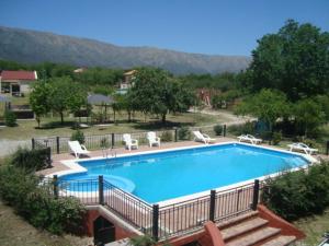 a large swimming pool with lounge chairs at La Candida Hotel in Merlo
