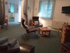 a living room with chairs and a table and a tv at Ferienwohnung Windecker Ländchen in Windeck