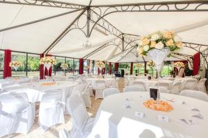 a marquee set up for a wedding with white tables and chairs at B&B Château De La Houssoye in La Houssoye