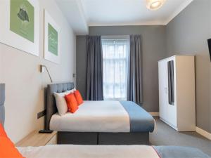 a bedroom with two beds and a window at OYO Townhouse Apollo, Hyde Park in London