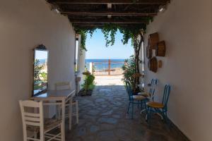 a room with a table and chairs and a view of the ocean at Athina Apartments in Palaiopoli