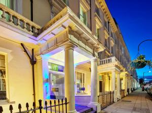 um edifício com colunas numa rua à noite em Holiday Inn Express London Victoria, an IHG Hotel em Londres