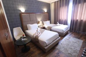 pokój hotelowy z 2 łóżkami i stołem w obiekcie Helnan Chellah Hotel w mieście Rabat