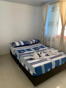 um quarto com uma cama com um cobertor azul e branco em Servituristicos La Esmeralda em Santa María
