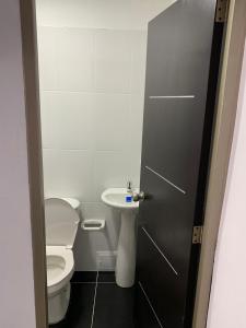 a bathroom with a toilet and a sink at Servituristicos La Esmeralda in Santa María