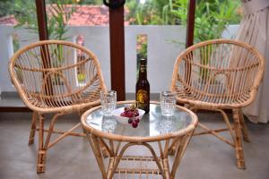 two chairs and a table with a bottle of wine at Lily Holiday Apartments in Hikkaduwa