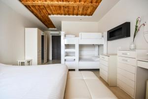 a bedroom with a white bed and a tv at Archontiko Liamas in Stavros +37 photos