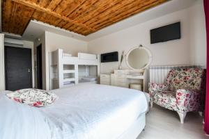 a bedroom with a bed and a chair and a mirror at Archontiko Liamas in Stavros