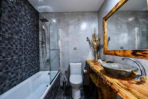 a bathroom with a sink and a tub and a toilet at Archontiko Liamas in Stavros