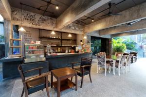 een restaurant met een bar en tafels en stoelen bij Capital O 464 At Nata Chiangmai Chic Jungle in Mae Rim