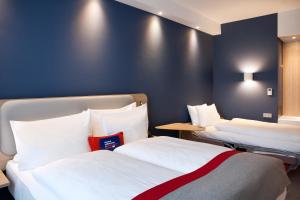 a room with two beds and a blue wall at Holiday Inn Express - Darmstadt, an IHG Hotel in Darmstadt