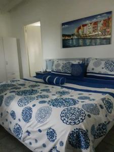 a blue and white bed with a blue and white comforter at Palm Trees Apartments in Willemstad