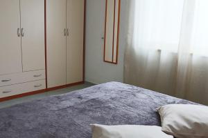 a bedroom with a bed and cabinets and a window at Holiday Apartment Karm Otranto 6 places in Otranto