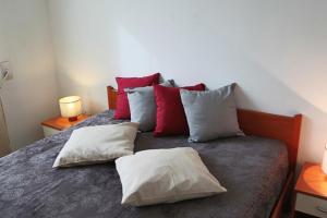 a bedroom with a bed with red and white pillows at Holiday Apartment Karm Otranto 6 places in Otranto