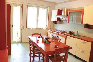 a kitchen with a wooden table and chairs in a kitchen at Holiday Apartment Karm Otranto 6 places in Otranto
