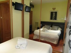 a hotel room with two beds and a mirror at Centroapartament Las Letras in Madrid
