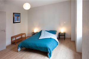 a bedroom with a blue bed and two night stands at LE TOMIGITE in Dimbsthal