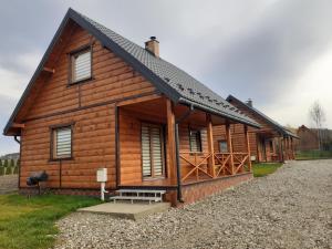 une cabane en rondins avec un banc devant elle dans l'établissement Sloneczny Domek, à Kacwin