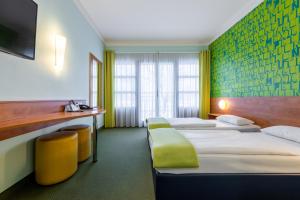 Habitación de hotel con 3 camas y escritorio. en Hotel Fränkische Schweiz-Pegnitz en Pegnitz