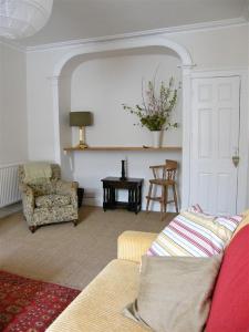 a living room with a couch and a chair at 57 High Street in Kirkcudbright