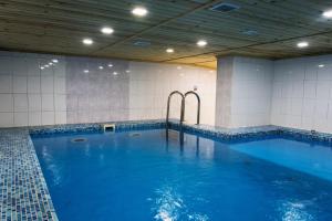 uma grande piscina interior com água azul em Hotel Regensburg.Life em Staroye Mart'yanovo