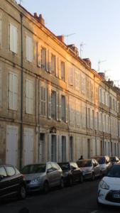 Petite Roche gîtes centre-ville La Rochelle في لا روشيل: صف من السيارات تقف امام مبنى