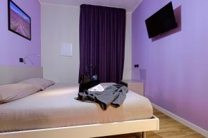 ein Schlafzimmer mit einem Bett mit lila Wänden in der Unterkunft Millefiori in Cagliari