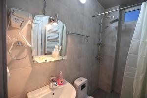 a bathroom with a sink and a shower with a mirror at Hotel Caucase in Tbilisi City +23 photos