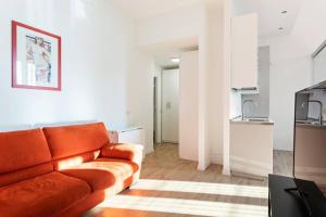 un soggiorno con divano arancione e una cucina di Spacious flat close to Fondazione Prada & Metro a Milano