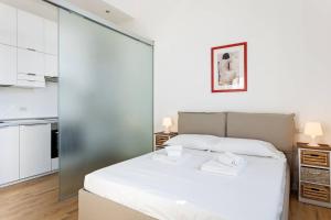 una camera con letto bianco e una cucina di Spacious flat close to Fondazione Prada & Metro a Milano