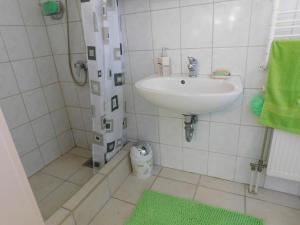 a white bathroom with a sink and a shower at Aranyalma Vendégház in Gárdony