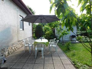 einen Tisch und Stühle mit Sonnenschirm auf einer Terrasse in der Unterkunft Aranyalma Vendégház in Gárdony