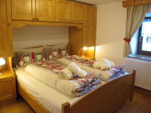 - une chambre avec un grand lit et un cadre en bois dans l'établissement Ospitalità Diffusa Laste Dolomites - Cèsa Murer, à Pallua