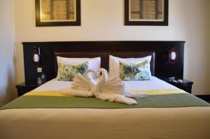 two swansrendered to look like they are kissing on a bed at Majestic Five Hotel in Palatswe