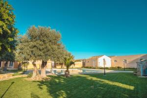 a yard with two trees and a swimming pool at Masseria Testaferrata in Syracuse