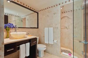 a bathroom with a sink and a glass shower at El Taj Oceanfront and Beachside Condo Hotel in Playa del Carmen