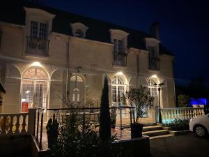 een groot wit gebouw met 's nachts verlichting bij La Carrière in Charentilly