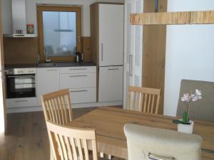 uma cozinha com uma mesa de jantar em madeira e cadeiras em Bergappartement Talblick em Sankt Veit in Defereggen