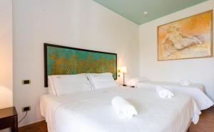 1 dormitorio con 2 camas blancas y una pintura en la pared en Hotel Garden, en Vulcano