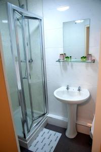 a bathroom with a sink and a glass shower at Redbeck Motel in Wakefield